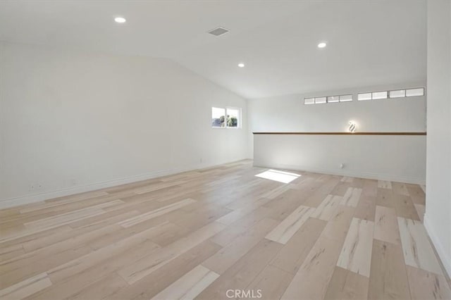 unfurnished room featuring light hardwood / wood-style flooring and vaulted ceiling