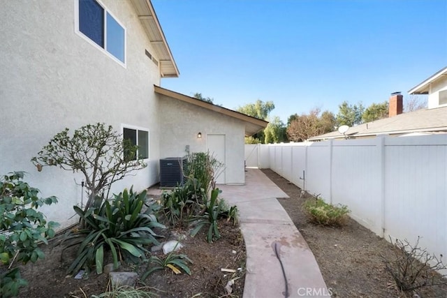 view of side of property featuring central air condition unit and a patio