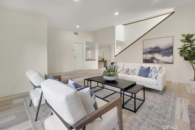 living room featuring light wood-type flooring and vaulted ceiling