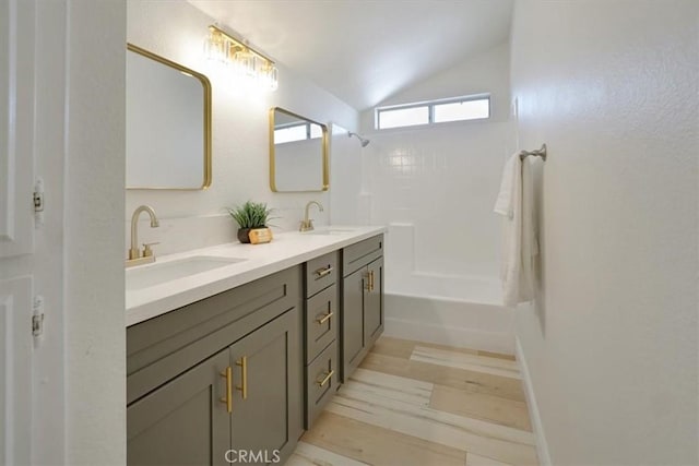 bathroom with vanity, vaulted ceiling, and shower / tub combination