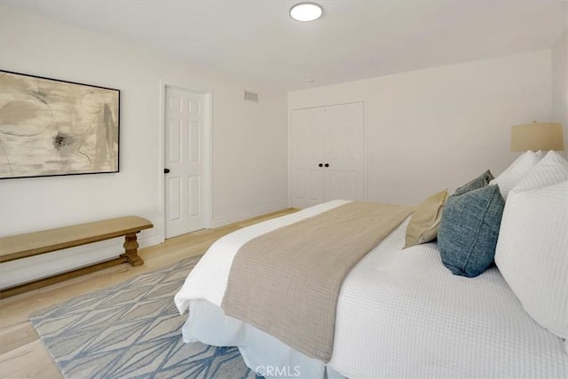 bedroom with a closet and light hardwood / wood-style flooring