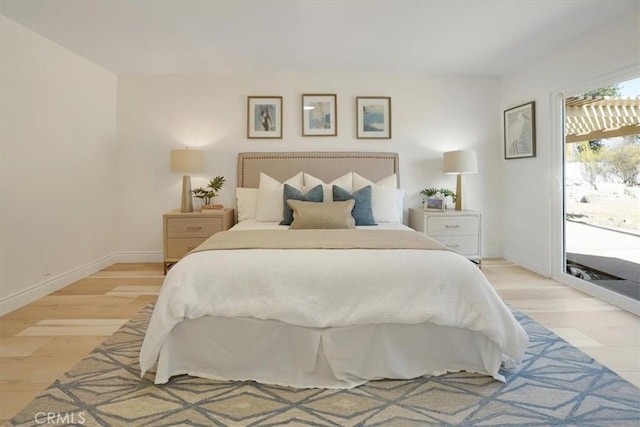 bedroom with light wood-type flooring and access to outside