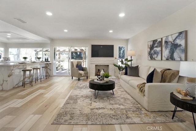 living room with light wood-type flooring and a fireplace