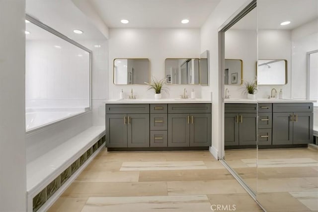 bathroom with vanity, a bathing tub, and hardwood / wood-style flooring