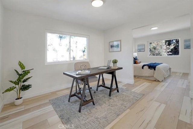 home office with light hardwood / wood-style flooring