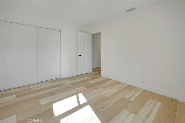 unfurnished bedroom featuring a closet and light hardwood / wood-style floors