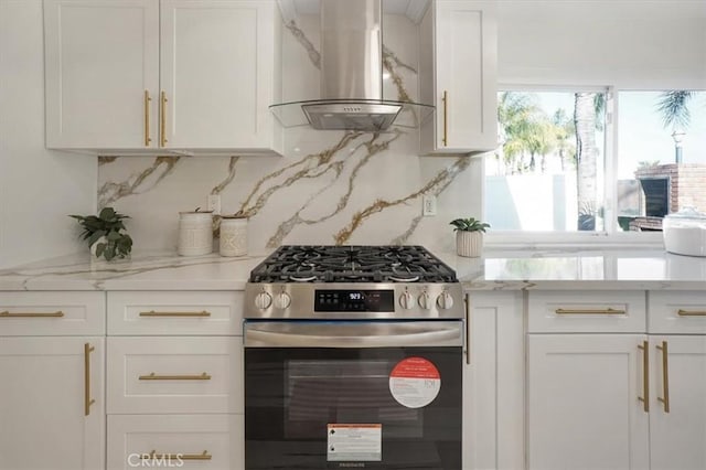 kitchen featuring extractor fan, gas stove, backsplash, light stone countertops, and white cabinets