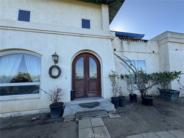 doorway to property featuring stucco siding