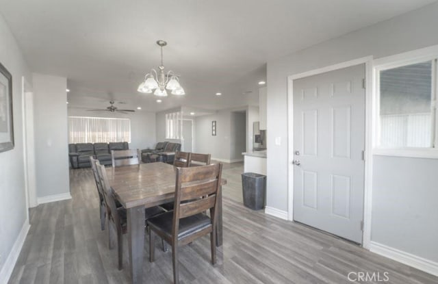 dining room with ceiling fan with notable chandelier and hardwood / wood-style floors