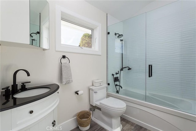 full bathroom with toilet, vanity, combined bath / shower with glass door, and hardwood / wood-style floors