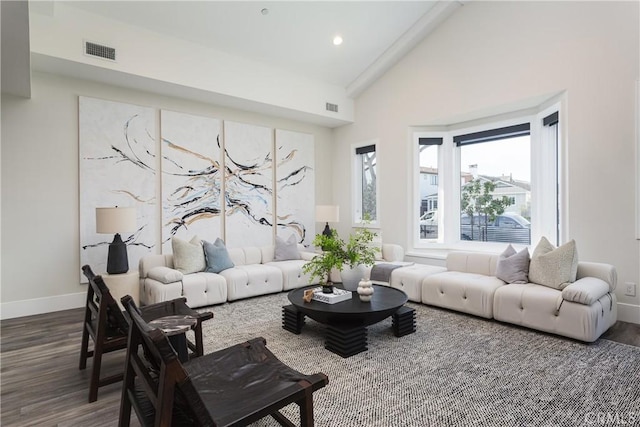 living room with dark hardwood / wood-style flooring, high vaulted ceiling, and beam ceiling