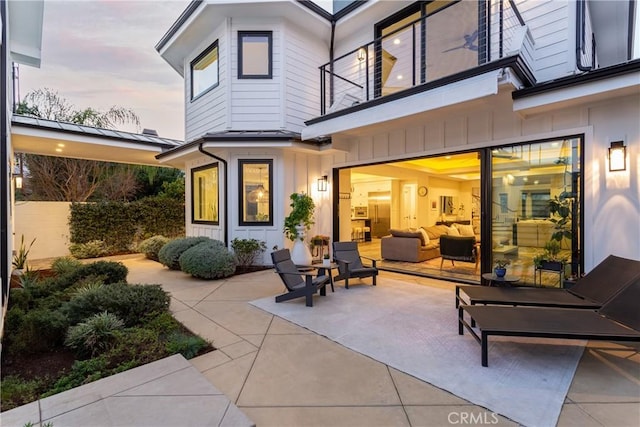 patio terrace at dusk featuring an outdoor living space