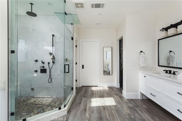 bathroom featuring hardwood / wood-style flooring, vanity, and walk in shower