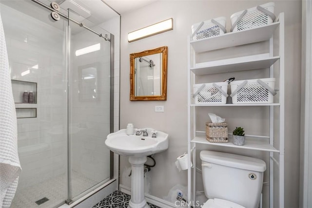 bathroom featuring toilet and a shower with door