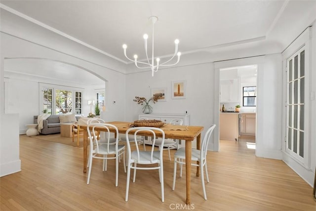 dining space featuring light hardwood / wood-style flooring and a notable chandelier