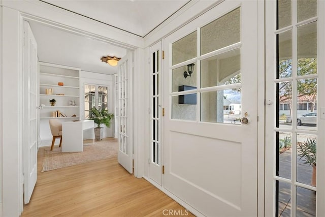 entryway with hardwood / wood-style flooring, built in features, and french doors