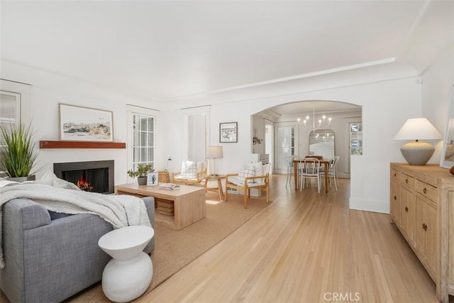 living room with light wood-type flooring and a notable chandelier