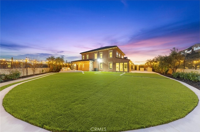 property exterior at dusk with a yard