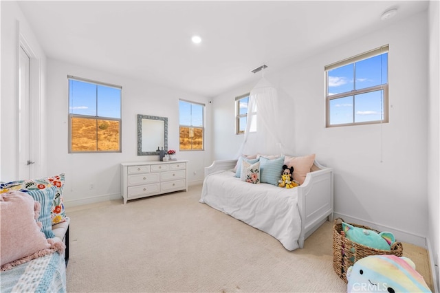 bedroom featuring multiple windows and light colored carpet