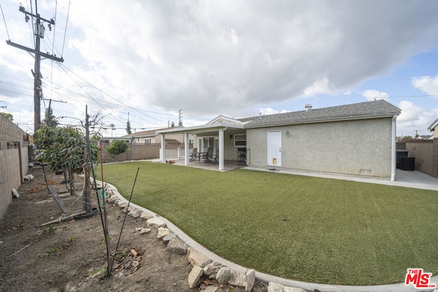 back of house featuring a patio and a lawn