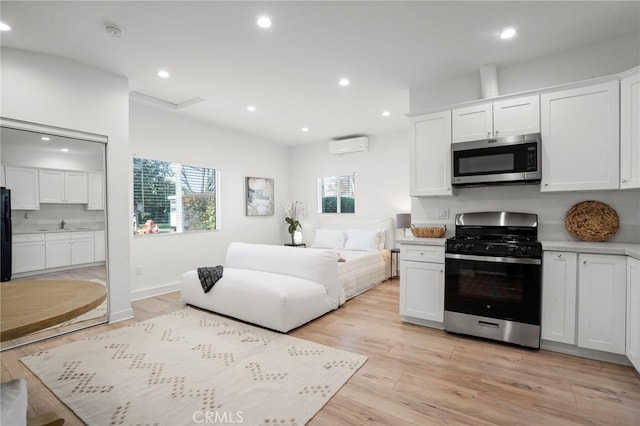 kitchen with light hardwood / wood-style flooring, plenty of natural light, stainless steel appliances, and white cabinetry