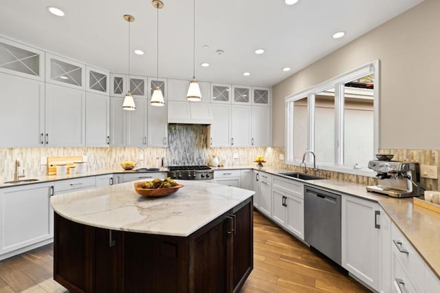 kitchen with white cabinetry, sink, dishwasher, and a kitchen island