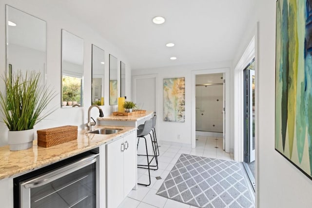 kitchen featuring white cabinetry, sink, a wealth of natural light, and beverage cooler