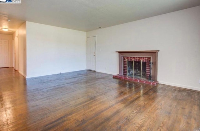 unfurnished living room featuring dark wood-type flooring and a fireplace