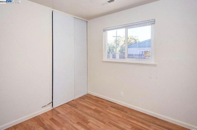 unfurnished bedroom featuring a closet and light hardwood / wood-style floors