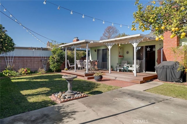 back of property featuring a patio area, a wooden deck, and a lawn