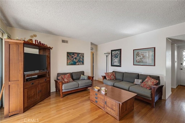 living room featuring a textured ceiling and light hardwood / wood-style floors