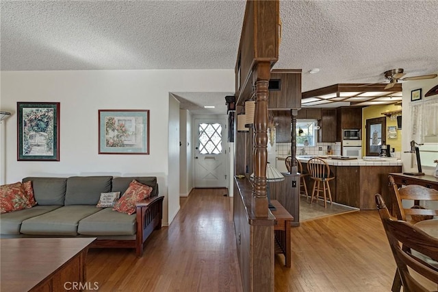 living room featuring a textured ceiling and light wood-type flooring