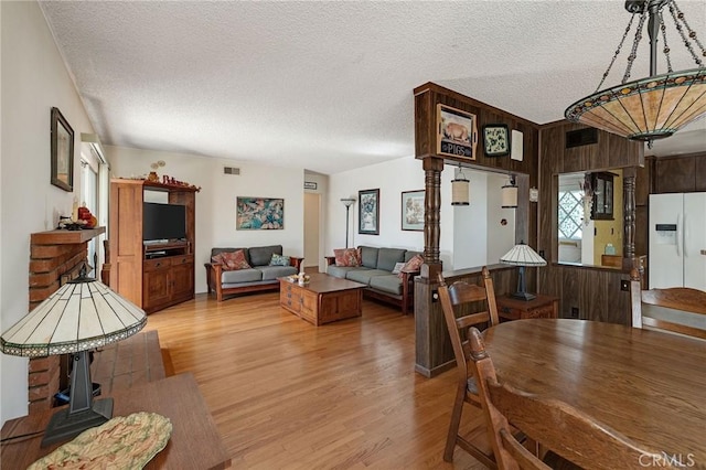 dining space with hardwood / wood-style flooring, a textured ceiling, and wood walls