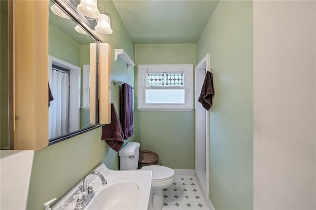 bathroom with toilet, sink, and curtained shower