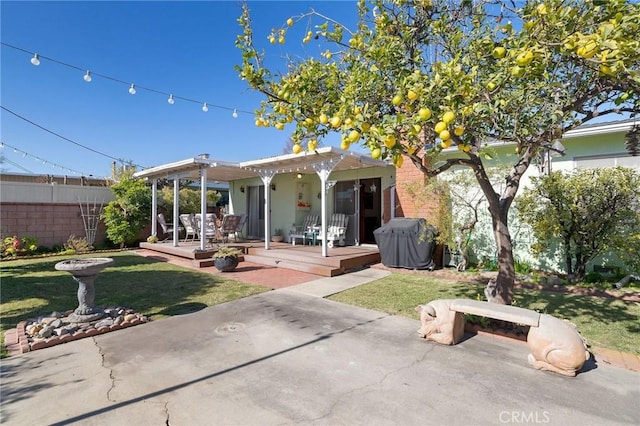 rear view of house with a pergola, a patio area, and a yard