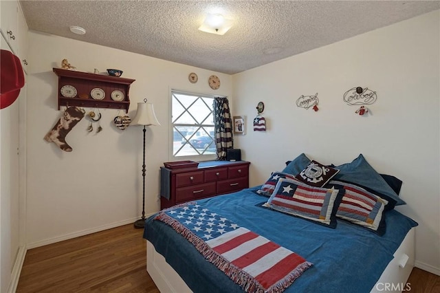 bedroom with dark wood-type flooring and a textured ceiling