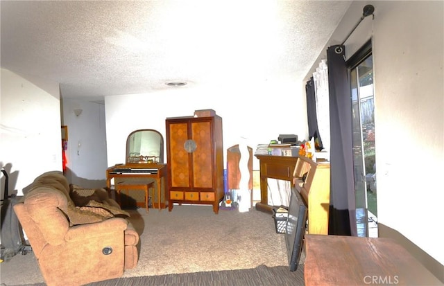 carpeted living room featuring a textured ceiling