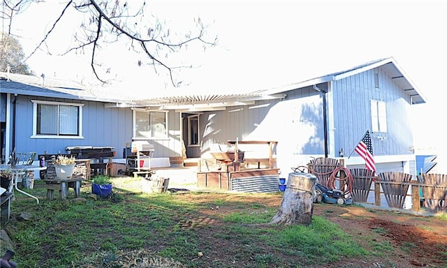 rear view of property featuring a pergola