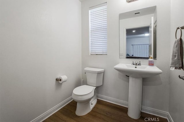 bathroom with toilet, hardwood / wood-style flooring, and sink