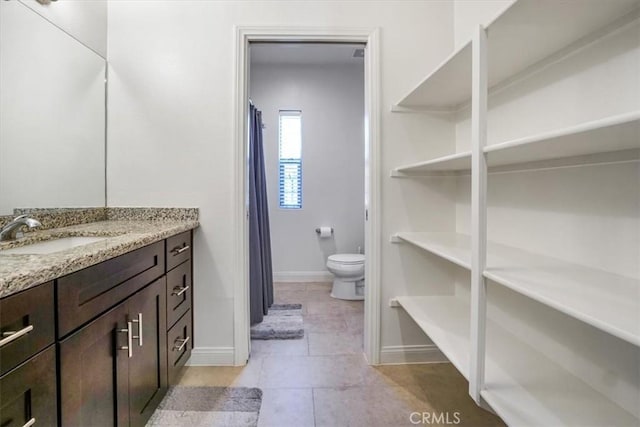 bathroom featuring toilet, tile patterned flooring, and vanity