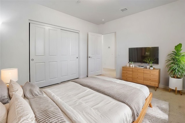 bedroom with light colored carpet and a closet