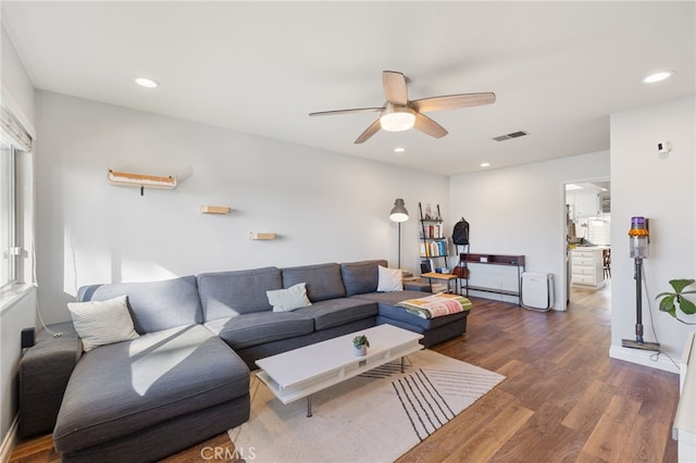 living room featuring dark hardwood / wood-style flooring and ceiling fan