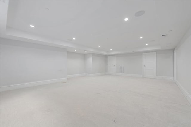 carpeted spare room featuring a raised ceiling