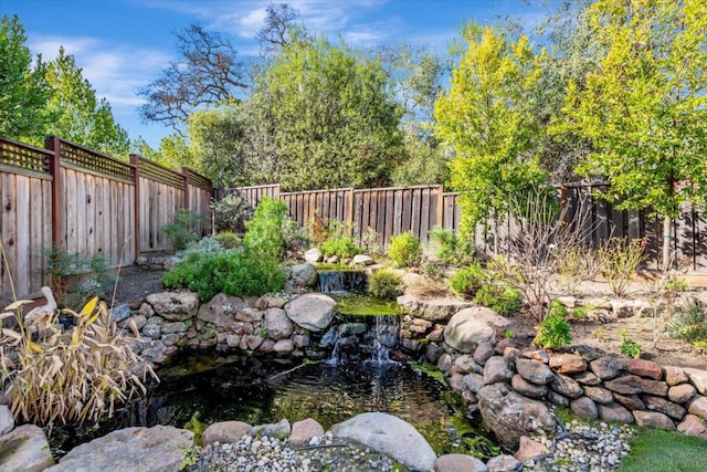 view of yard featuring a small pond