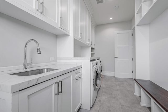 washroom with sink, cabinets, and washer and dryer