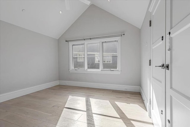 spare room featuring lofted ceiling and light hardwood / wood-style flooring