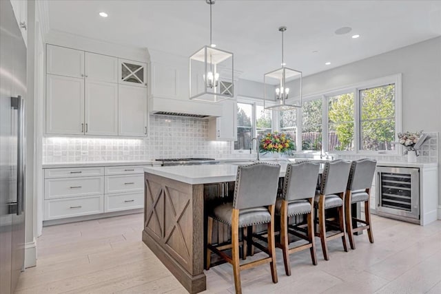 kitchen featuring white cabinets, a kitchen island, high end refrigerator, and beverage cooler