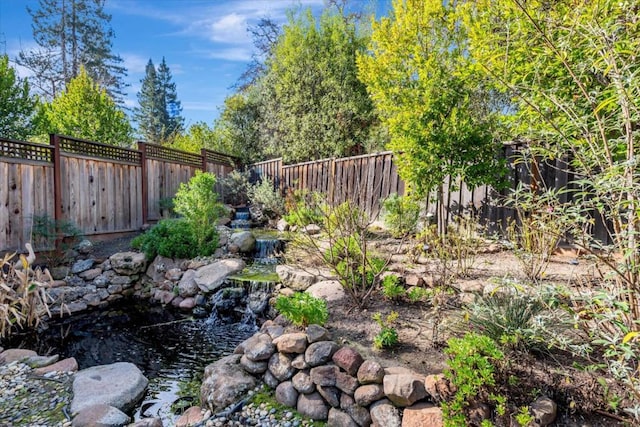 view of yard featuring a small pond