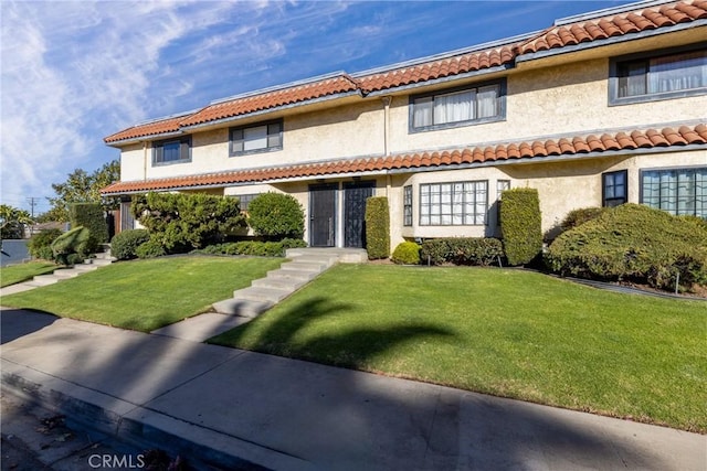 405 W Mountain View Ave Unit 11, La Habra, CA 90631 - mediterranean / spanish-style house featuring a tile roof, a front lawn, and stucco siding