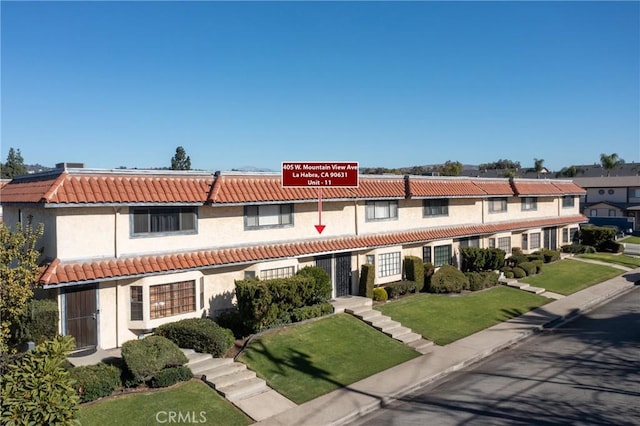 405 W Mountain View Ave Unit 11, La Habra, CA 90631 - view of front facade featuring a tiled roof, a front lawn, and stucco siding